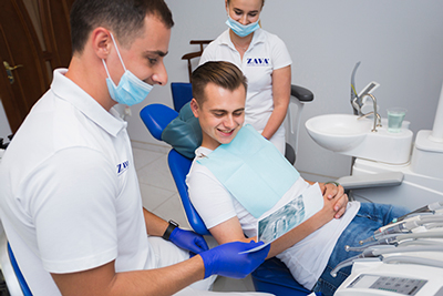 dentist and patient smiling and looking at radiography ZAVATESLA Hướng Dẫn Chăm Sóc Răng Sau Khi Niềng - Giữ Kết Quả Bền Vững, Ngăn Ngừa Tái Lệch chăm sóc răng chăm sóc răng